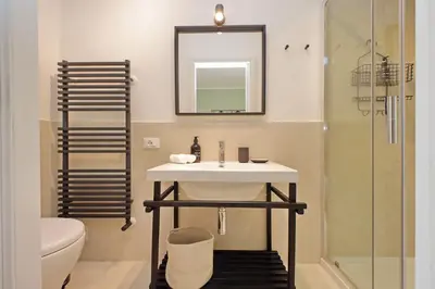 a bathroom with a sink and a toilet and a mirror at Porta Flaminia Suites in Rome