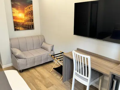 a living room with a couch and a chair and a television at Niky House Roma in Rome