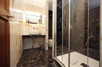 a bathroom with a sink and a shower with a mirror at Golden Pantheon Rooms in Rome