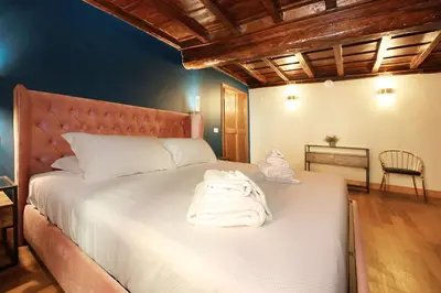 a bedroom with a bed with towels on it at Golden Pantheon Rooms in Rome