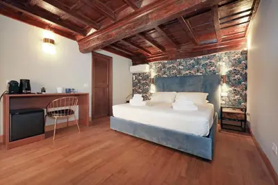 a bedroom with a white bed and a tv at Golden Pantheon Rooms in Rome