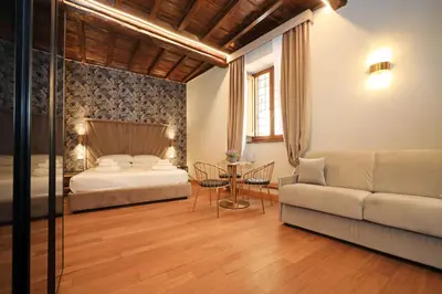 a bedroom with a bed and a couch and a table at Golden Pantheon Rooms in Rome