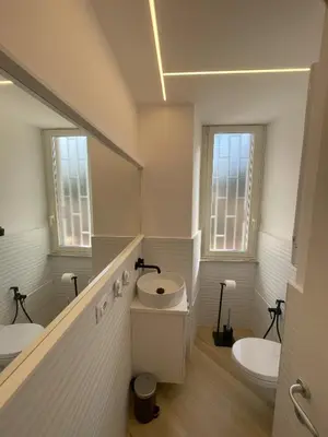 a white bathroom with two sinks and a mirror at Vatican Hill Apt in Rome