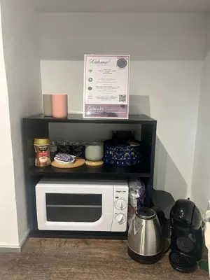 a microwave on a shelf with a box on top at Gracchi boutique rooms in Rome