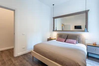 a bedroom with a large bed with a mirror on the wall at Gracchi boutique rooms in Rome