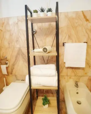 a bathroom with a shelf with towels and a sink at Millelire Vatican Terrace in Rome