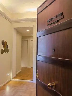 a wooden door with a sign on it next to a hallway at Metro Lodi Apartment in Rome