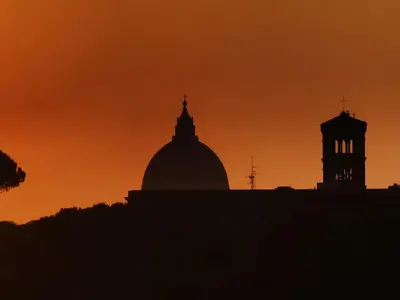 a silhouette of a building with a sunset in the background at Metro Lodi Apartment in Rome