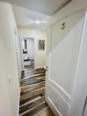 a hallway with a white door and wooden floors at SD Vatican Rooms in Rome