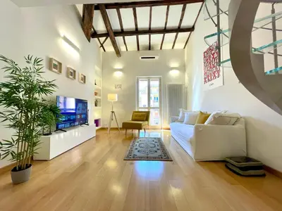 a living room with a white couch and a tv at Vittoria's home in Rome