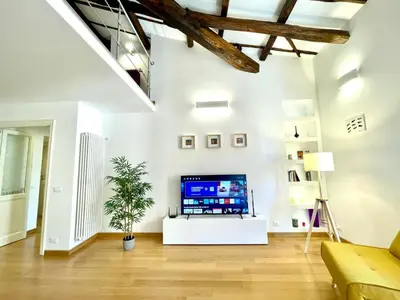 a living room with a tv on a white wall at Vittoria's home in Rome