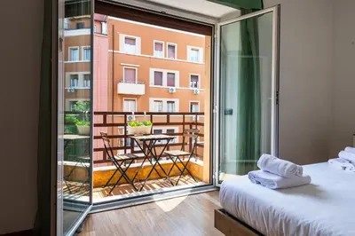 a room with a balcony with a bed and a table at Re di Roma Lodge in Rome