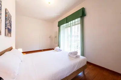 a bedroom with a large white bed and a window at Re di Roma Lodge in Rome