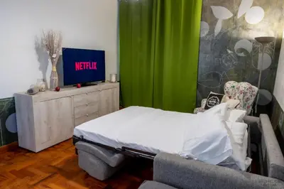 a bedroom with a bed and a green curtain at Green Hill Rome Suite Home in Rome