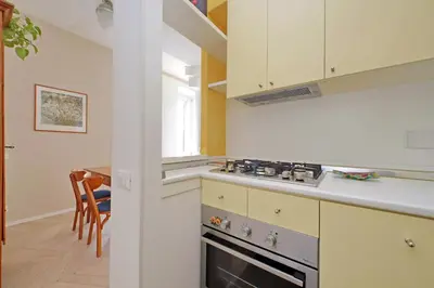 a kitchen with white cabinets and a stove top oven at YCH-Casa sul porto antico in Rome