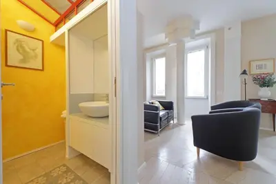 a bathroom with a sink and a chair and a mirror at YCH-Casa sul porto antico in Rome