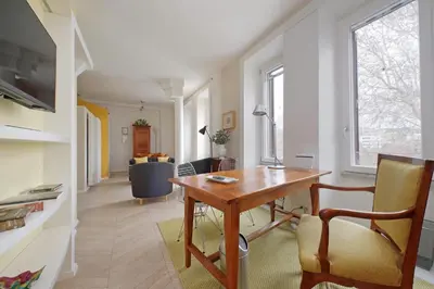 a living room with a wooden table and a chair at YCH-Casa sul porto antico in Rome