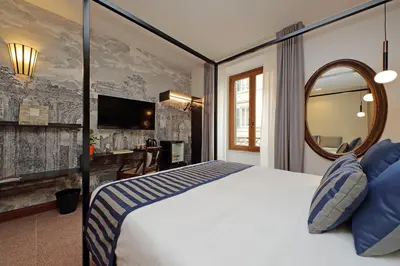 a bedroom with a bed with a mirror and a desk at Habito Suites in Rome