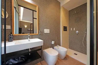 a bathroom with a sink and a toilet and a mirror at Habito Suites in Rome