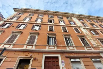 a tall orange building with windows and a door at Habito Suites in Rome