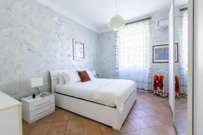 a bedroom with a white bed and white walls at Casa Lodi Roma by Hili in Rome