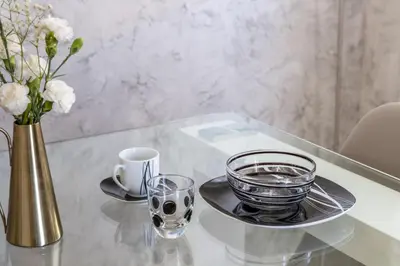 a glass table with a plate and a vase of flowers at Casa Lodi Roma by Hili in Rome