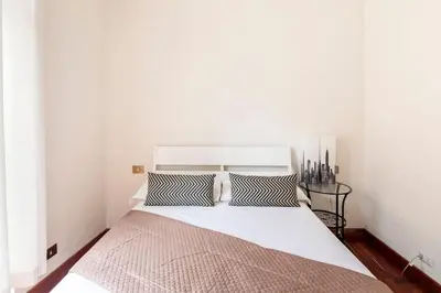 a white bed with two pillows in a bedroom at Villa Borghese cozy apt in Rome