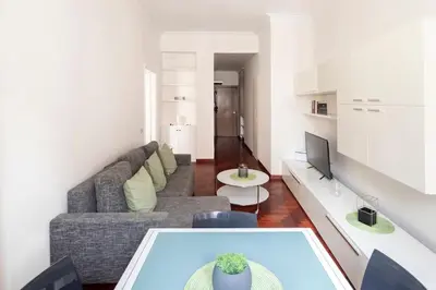 a living room with a couch and a tv at Villa Borghese cozy apt in Rome