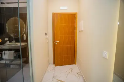 a bathroom with a wooden door and a marble floor at Vespucci Palace Roma in Rome