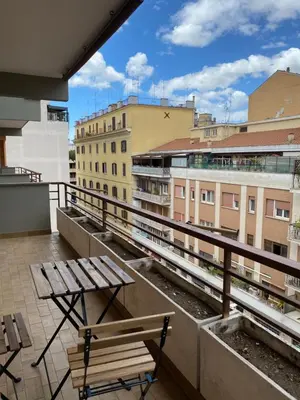 a balcony with benches and tables on a building at Saluzzo Apartment in Rome