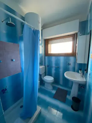 a blue bathroom with a toilet and a sink at Saluzzo Apartment in Rome