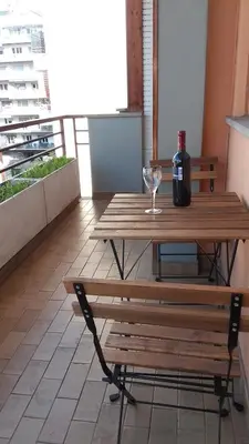 a wooden table with a bottle of wine and a wine glass at Saluzzo Apartment in Rome