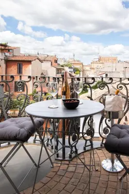 a table and two wine glasses on a balcony at Alessio Luxury House Roma Pantheon-Piazza Navona in Rome