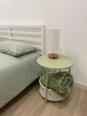 a table with a lamp on a bed next to a bedskirts at St Peter Family Stay in Rome