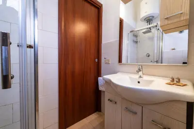 a bathroom with a sink and a mirror and a shower at Cipro Tiny House in Rome