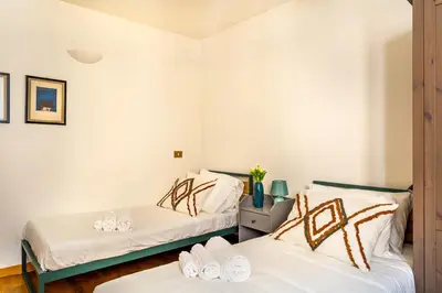 two beds in a room with white walls at iFlat Lovely 2 bedroom apartment in Rione Monti in Rome