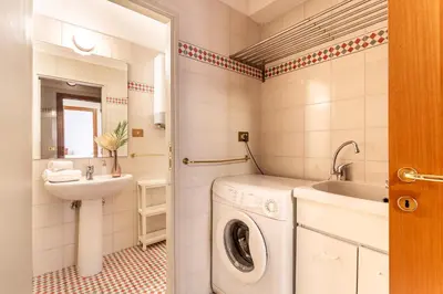 a bathroom with a washing machine and a sink at iFlat Lovely 2 bedroom apartment in Rione Monti in Rome
