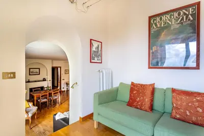 a living room with a green couch and a dining room at iFlat Lovely 2 bedroom apartment in Rione Monti in Rome