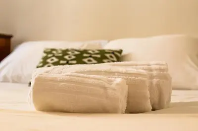 a white towel sitting on top of a bed at iFlat Lovely 2 bedroom apartment in Rione Monti in Rome