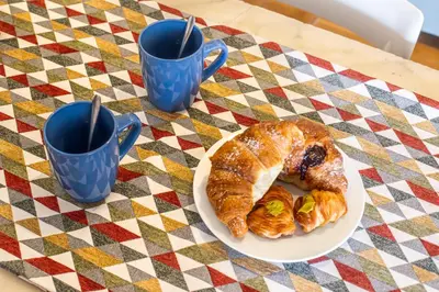 a plate of croissants and two cups on a table at iFlat Lovely 2 bedroom apartment in Rione Monti in Rome