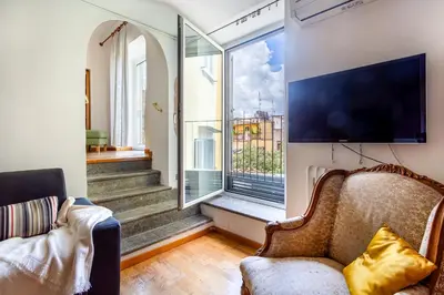 a living room with a couch and a large window at iFlat Lovely 2 bedroom apartment in Rione Monti in Rome
