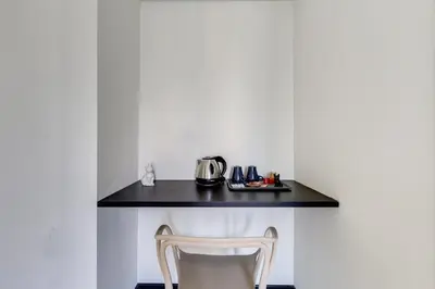 a table with a chair and a tea kettle on it at VIVILO COLLECTION - Muggia 21 Suites in Rome