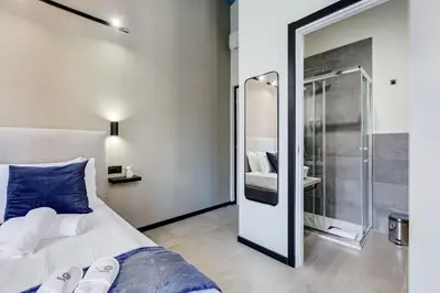 a bedroom with a bed and a glass shower at VIVILO COLLECTION - Muggia 21 Suites in Rome