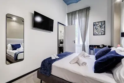 a bedroom with a large bed and a mirror at VIVILO COLLECTION - Muggia 21 Suites in Rome