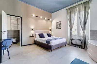 a bedroom with a bed and a tub and a sink at VIVILO COLLECTION - Muggia 21 Suites in Rome