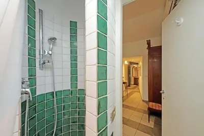 a bathroom with a shower with green and white tiles at Cavour in Rome