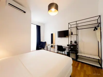 a bedroom with a white bed and a desk at Magikrooms Topaz in Rome