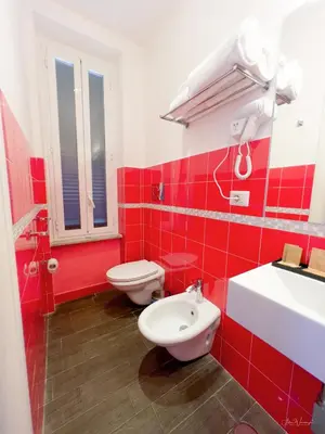 a red bathroom with a toilet and a sink at Magikrooms Topaz in Rome