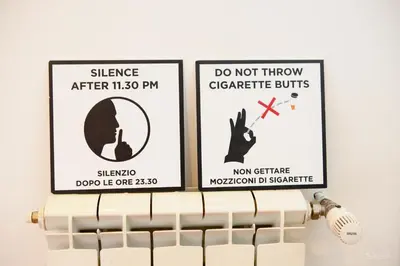 two signs on a radiator with a sign that says do not throw cigarette suits at Magikrooms Topaz in Rome