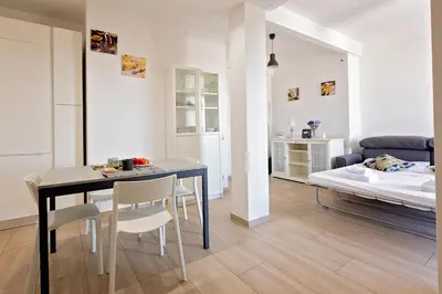a living room with a table and chairs and a bed at Ion Apartment in Rome